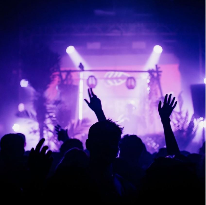 Silhouettes of people dancing in a nightclub.