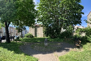 A garden with a terrace of houses in the background