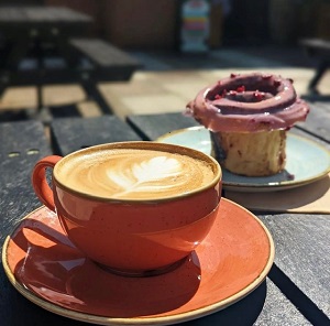 A cup of coffee and piece of cake on a table