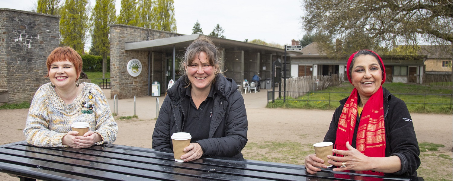 Three women enjoying hot drinks outside a cafe