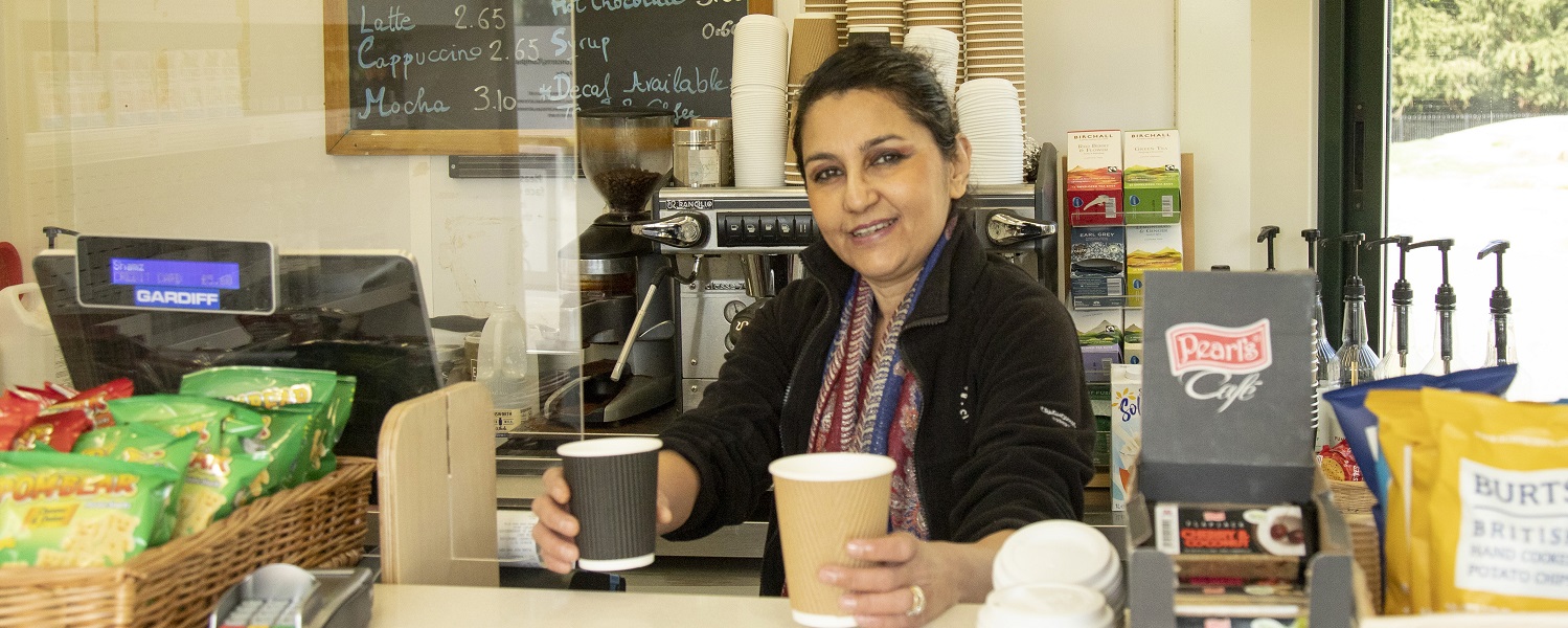 A member of staff serving drinks inside the cafe