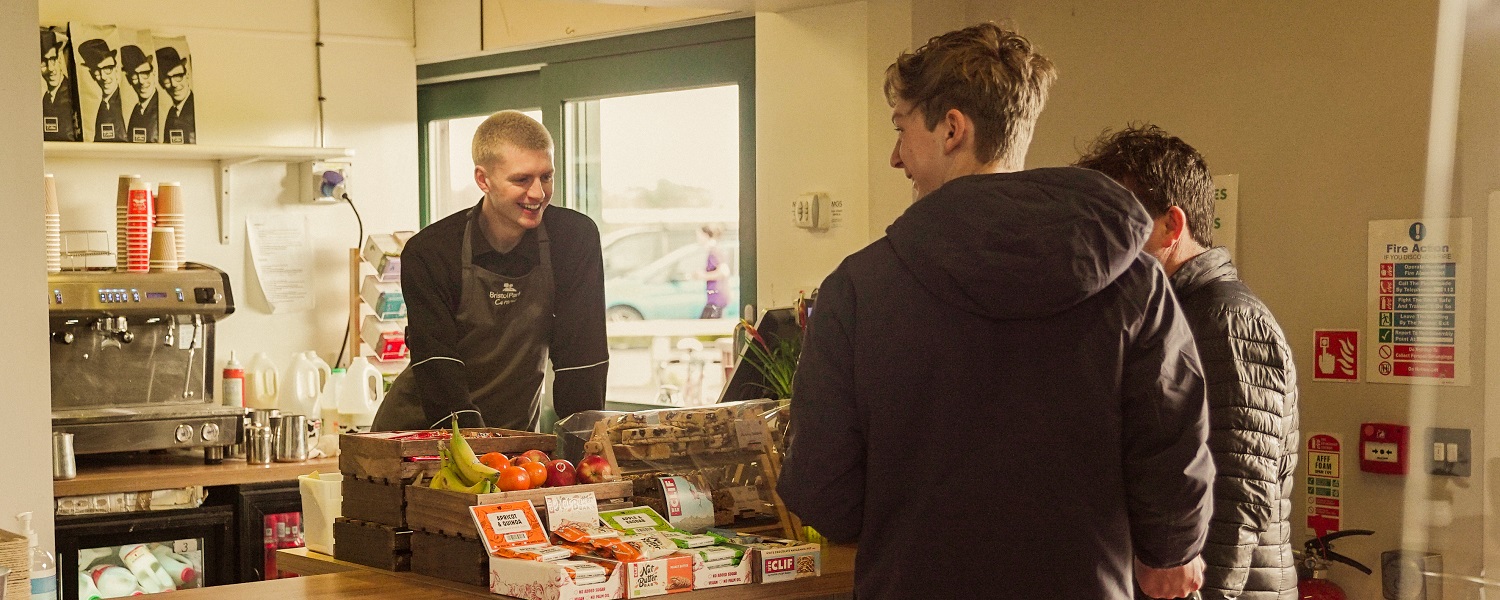 A member of staff serving two customers