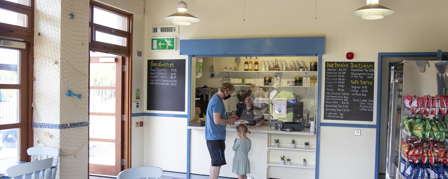 A man and a little girl being served by a member of staff