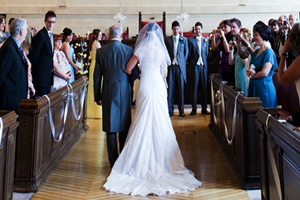 a man with a bride on his arm surrounded by wedding guests