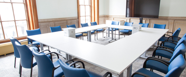 a large bright meeting room with a large table and floor to ceiling windows