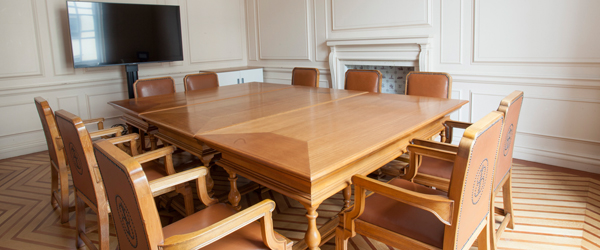 a heritage room with a square wooden table and leather chais