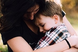 A young boy in the arms of a young woman