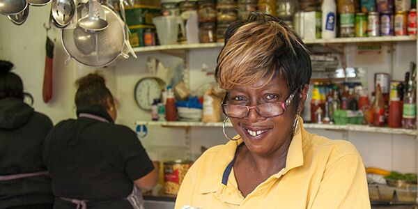 A lady with glasses on smiling at the camera