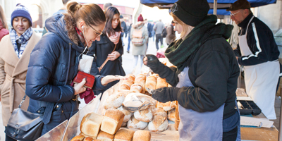 A lady buying bread at a market