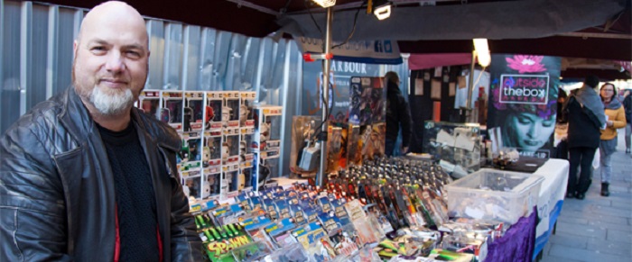 A man selling comics on a market stall