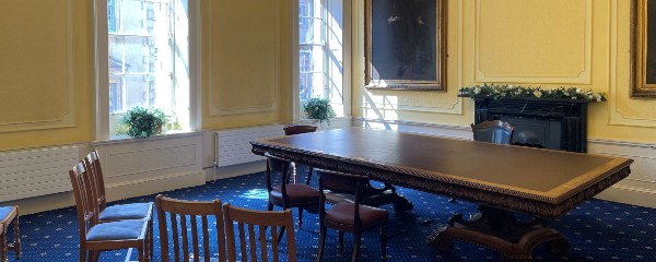 a small room with a table, chairs, and fireplace